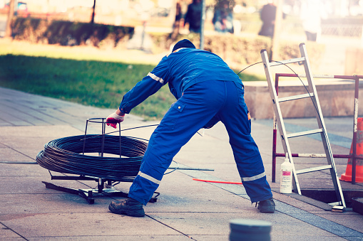 Worker pulls the fiber optic cable Pull Fiber Optic